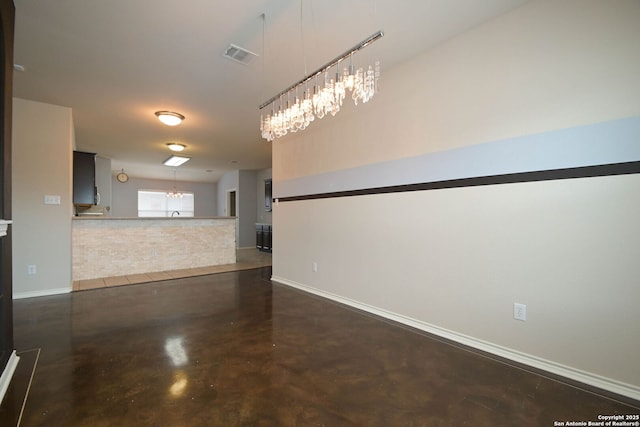 unfurnished room featuring a notable chandelier