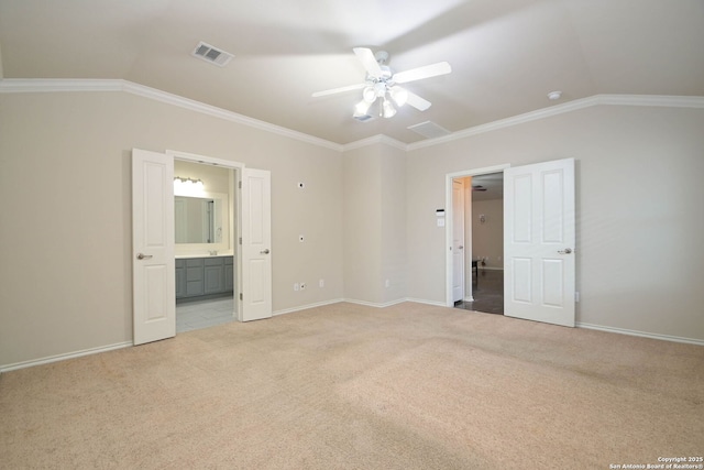 unfurnished bedroom with crown molding, ensuite bath, ceiling fan, light carpet, and vaulted ceiling