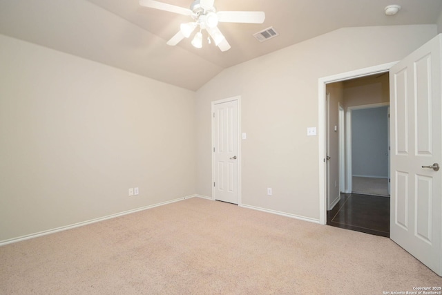 unfurnished bedroom with ceiling fan, light colored carpet, and vaulted ceiling