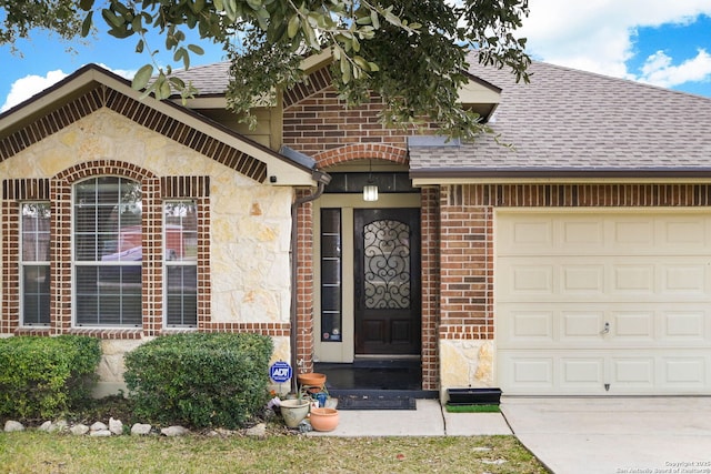 property entrance with a shingled roof, brick siding, and an attached garage