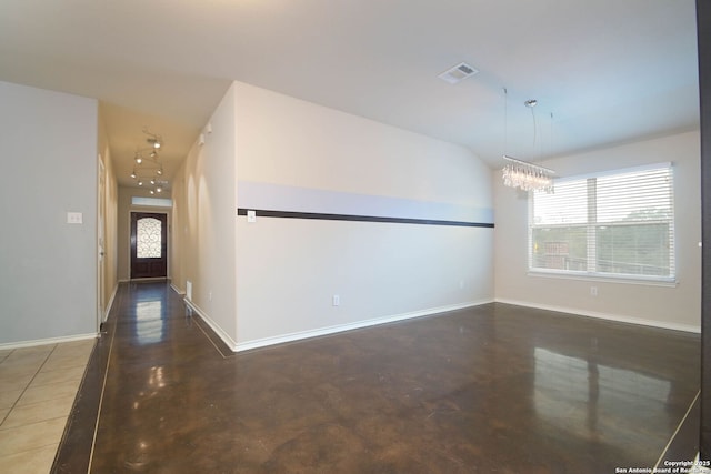 entrance foyer featuring a wealth of natural light, a chandelier, and vaulted ceiling