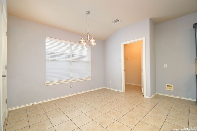 tiled empty room with lofted ceiling and an inviting chandelier