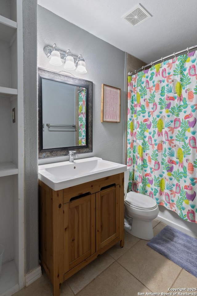 bathroom with vanity, toilet, and tile patterned flooring