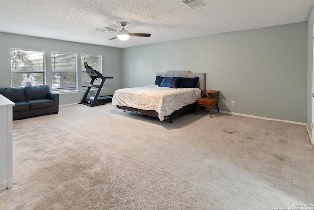 bedroom featuring light carpet, a textured ceiling, and ceiling fan