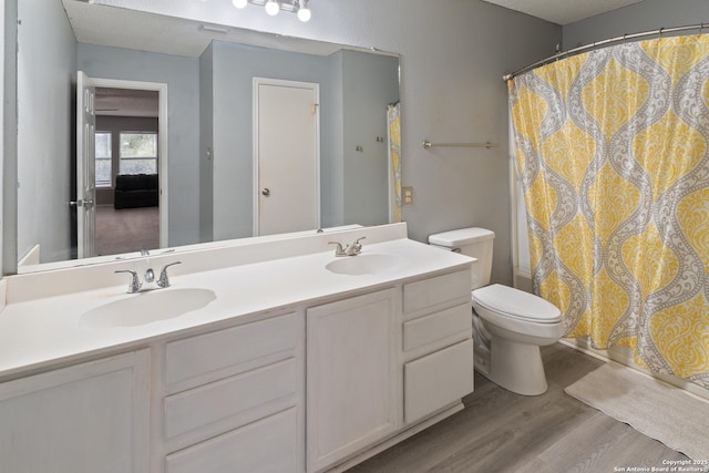 full bathroom with shower / tub combo with curtain, vanity, toilet, and hardwood / wood-style floors