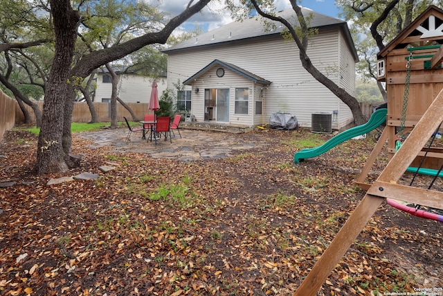 back of property featuring a playground, a patio area, and central air condition unit