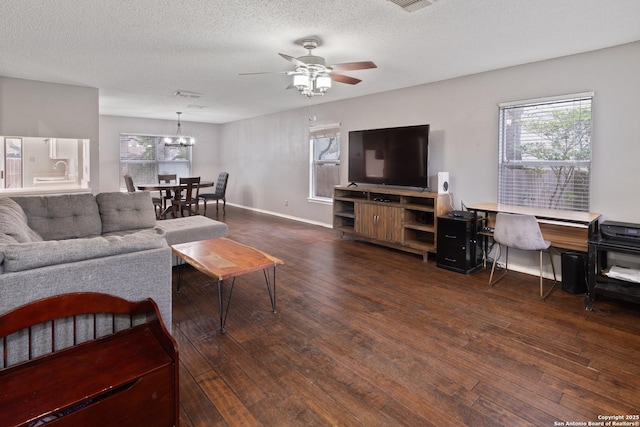 living room with a wealth of natural light, dark wood-type flooring, and a textured ceiling