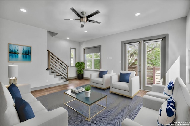 living room featuring wood-type flooring and ceiling fan