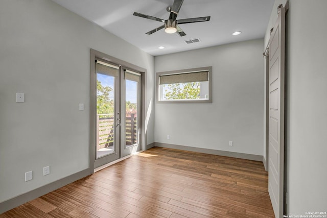 unfurnished room with ceiling fan, light wood-type flooring, and french doors