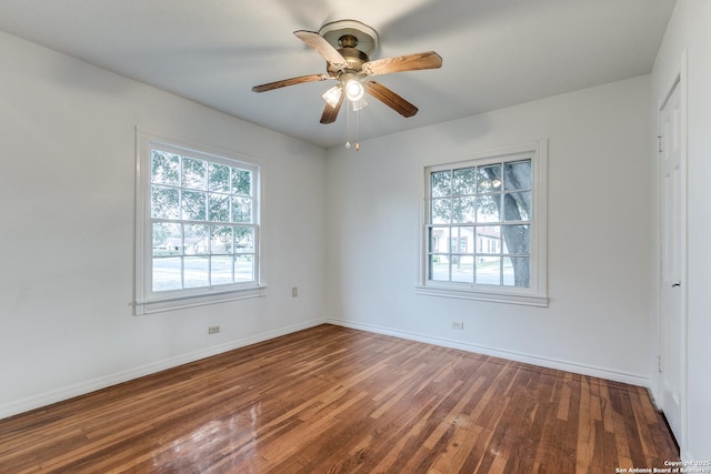 empty room featuring dark wood-type flooring and ceiling fan