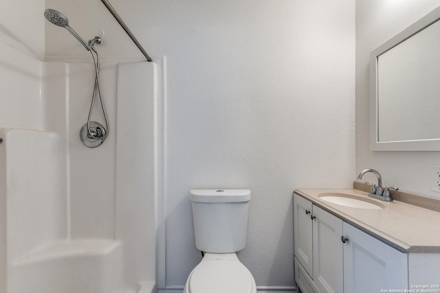 bathroom featuring vanity, toilet, and a shower