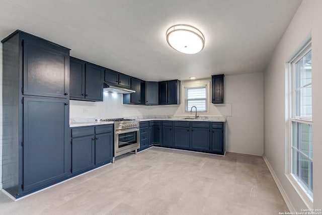 kitchen with blue cabinetry, sink, and high end range