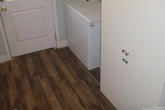 clothes washing area with dark hardwood / wood-style floors