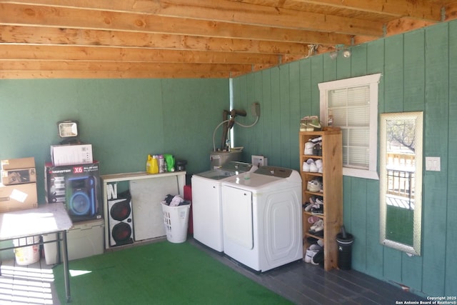 laundry area with wooden walls and independent washer and dryer