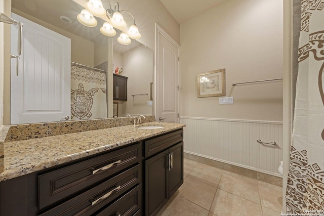 bathroom featuring an inviting chandelier, tile patterned floors, and vanity