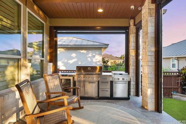 patio terrace at dusk featuring area for grilling