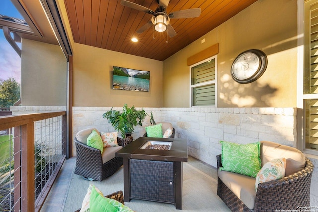 balcony with an outdoor living space with a fire pit and ceiling fan