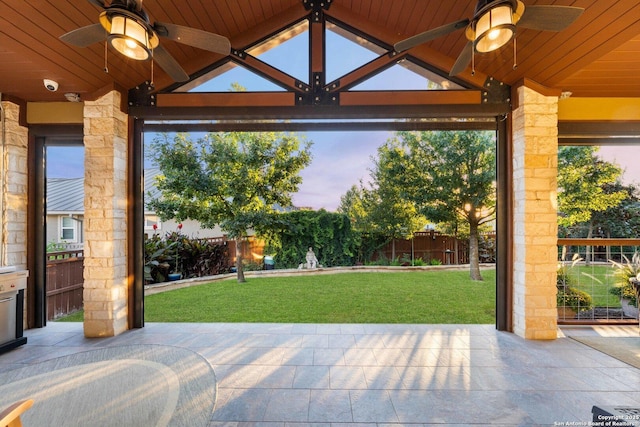 patio terrace at dusk featuring a yard and ceiling fan