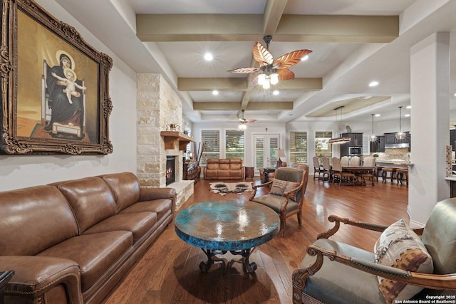 living room featuring a fireplace, wood-type flooring, coffered ceiling, and beam ceiling