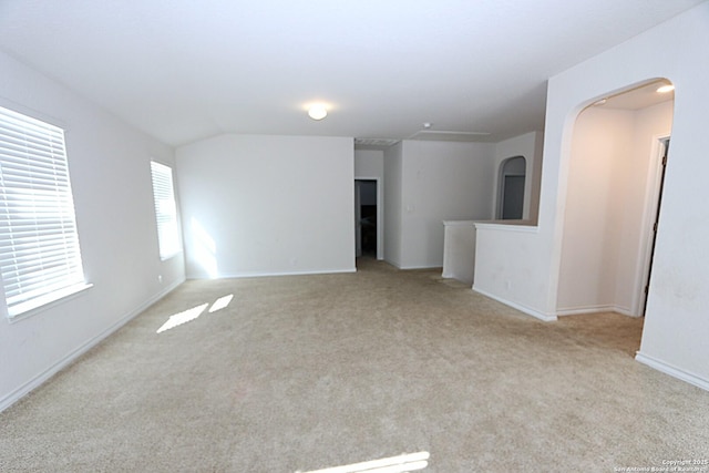 spare room with vaulted ceiling and light carpet