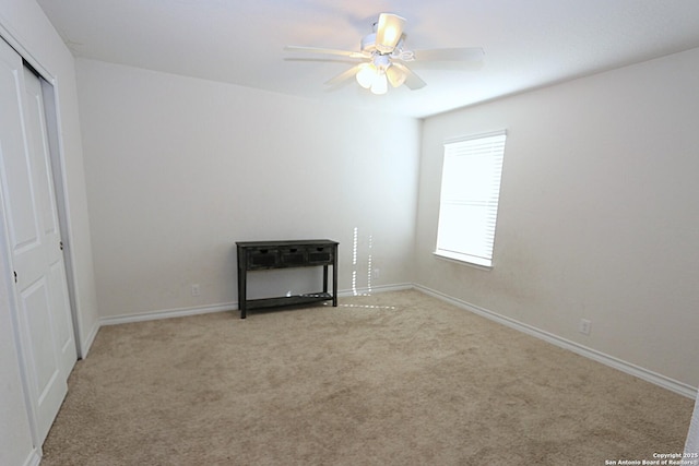 unfurnished bedroom featuring ceiling fan, a closet, and light carpet