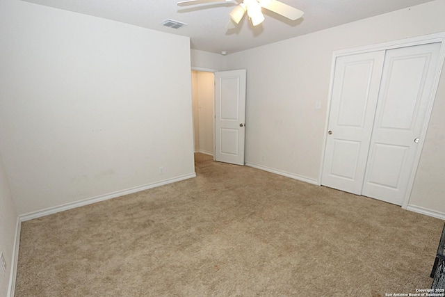 unfurnished bedroom featuring light carpet, a closet, and ceiling fan