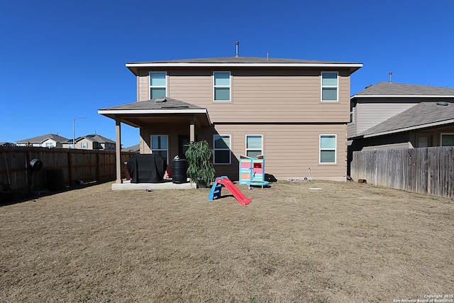 rear view of house with a patio and a yard