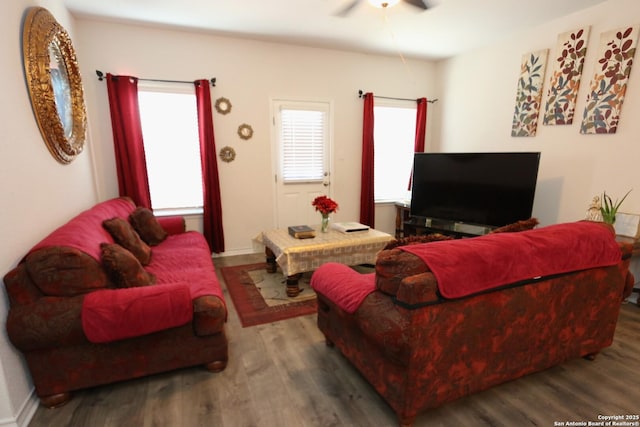 living room with dark hardwood / wood-style flooring, a wealth of natural light, and ceiling fan