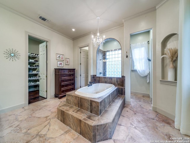 bathroom with ornamental molding, tiled bath, and a notable chandelier