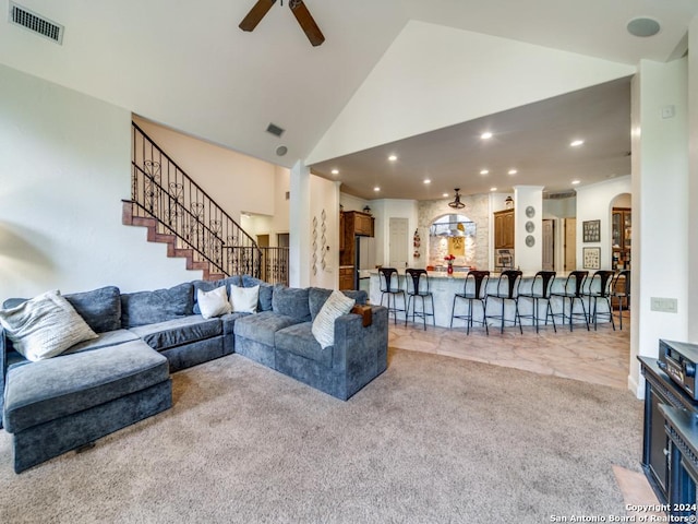 living room with ceiling fan, light carpet, and high vaulted ceiling