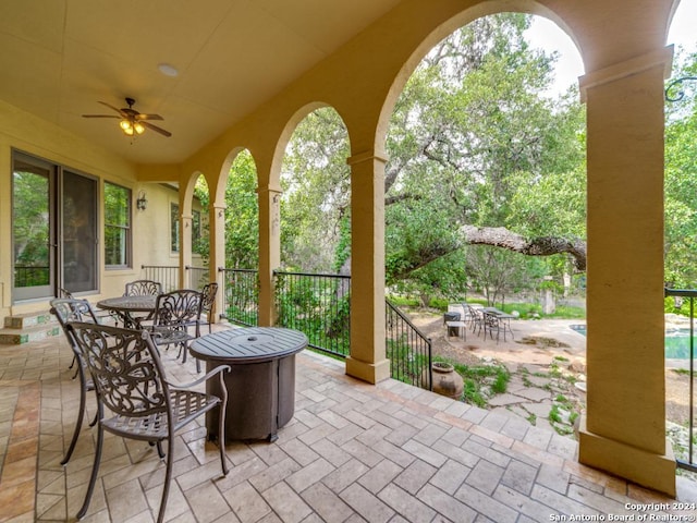 view of patio with ceiling fan and a fire pit