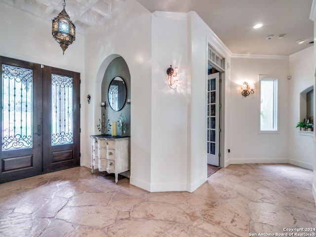 entryway featuring crown molding and french doors