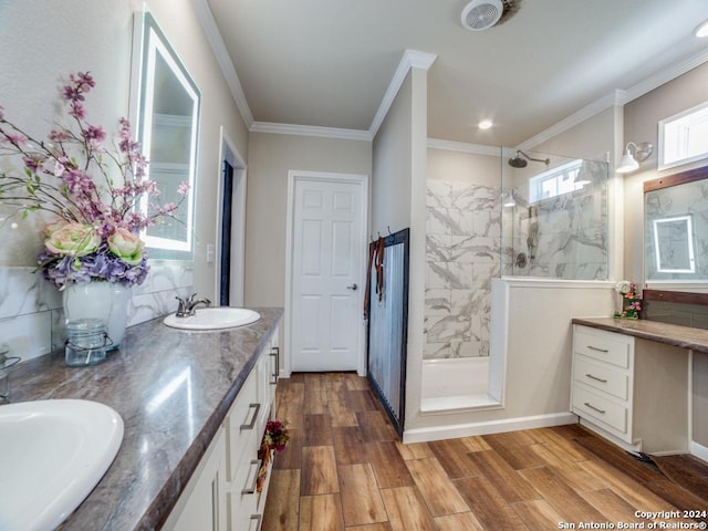 bathroom with a tile shower, hardwood / wood-style floors, vanity, and ornamental molding