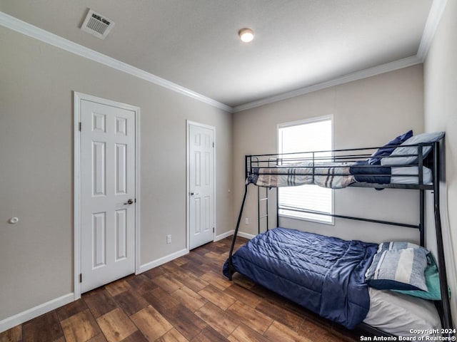 bedroom with dark wood-type flooring and crown molding