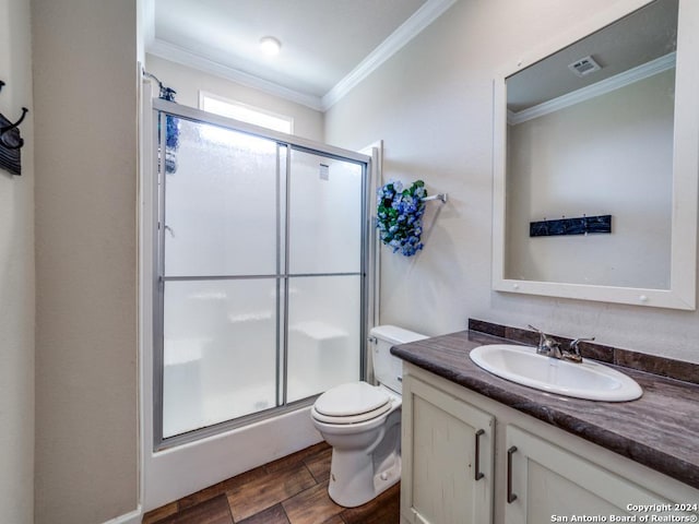 bathroom featuring an enclosed shower, ornamental molding, vanity, and toilet