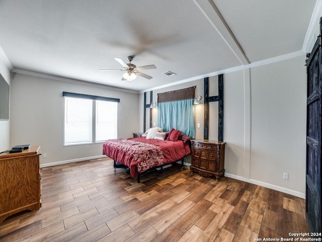 bedroom featuring crown molding, ceiling fan, a barn door, and hardwood / wood-style floors