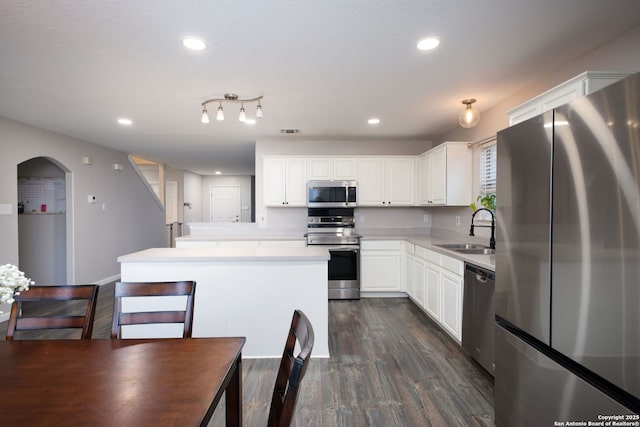 kitchen with sink, a center island, dark hardwood / wood-style flooring, stainless steel appliances, and white cabinets