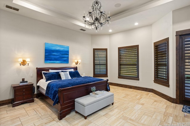 bedroom with a raised ceiling and a notable chandelier