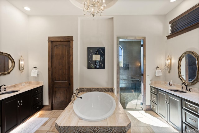 bathroom with an inviting chandelier, vanity, and independent shower and bath