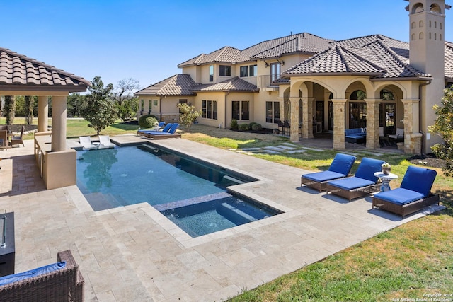 view of pool featuring an in ground hot tub, a lawn, and a patio