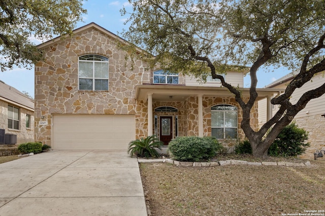 view of front of property featuring a garage and central AC