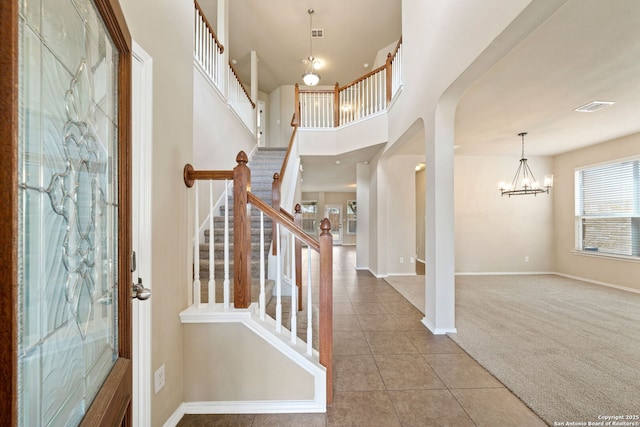 entrance foyer featuring an inviting chandelier and carpet floors