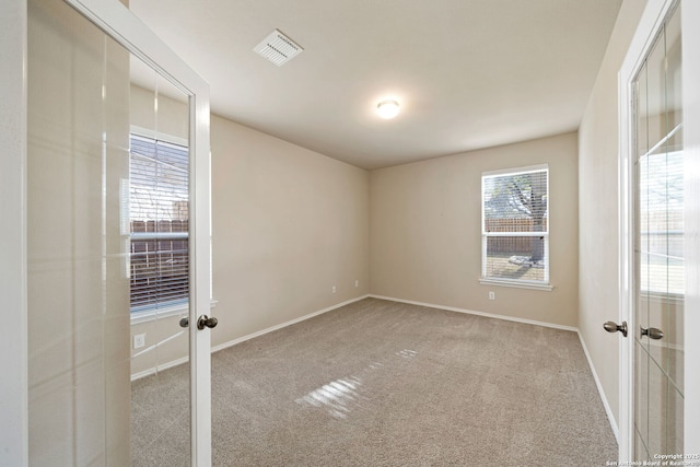 carpeted empty room featuring french doors