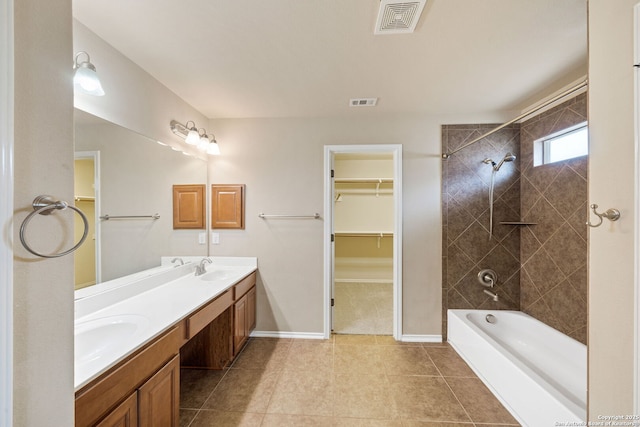 bathroom featuring vanity, tiled shower / bath combo, and tile patterned flooring