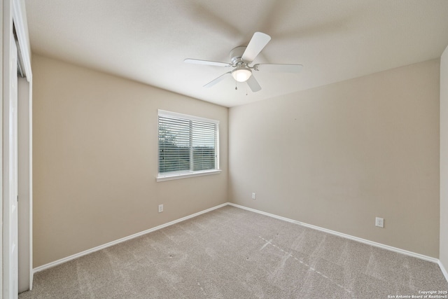 empty room featuring ceiling fan and light colored carpet