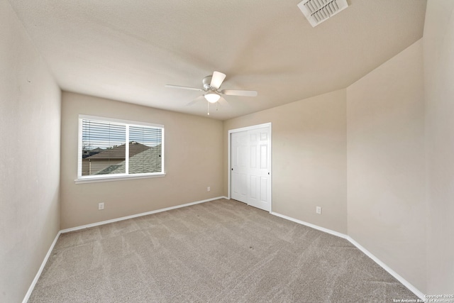 empty room with light colored carpet and ceiling fan