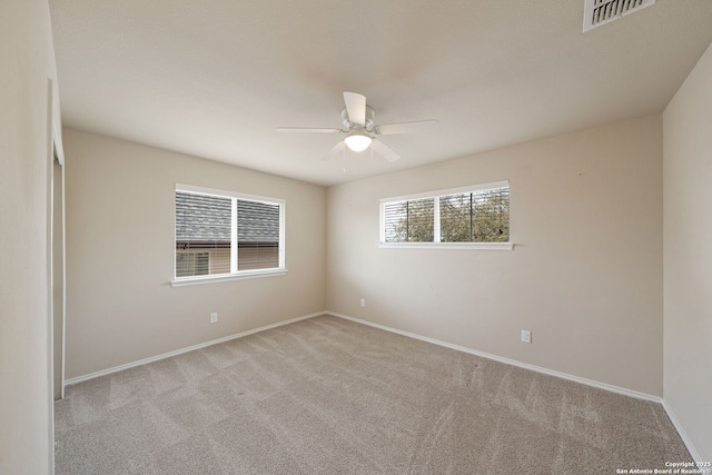 carpeted spare room with ceiling fan