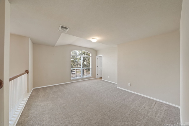 carpeted empty room with lofted ceiling