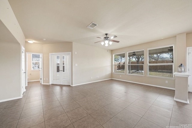 tiled empty room with ceiling fan and french doors