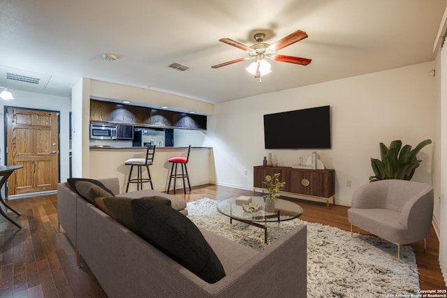 living room featuring dark hardwood / wood-style flooring and ceiling fan